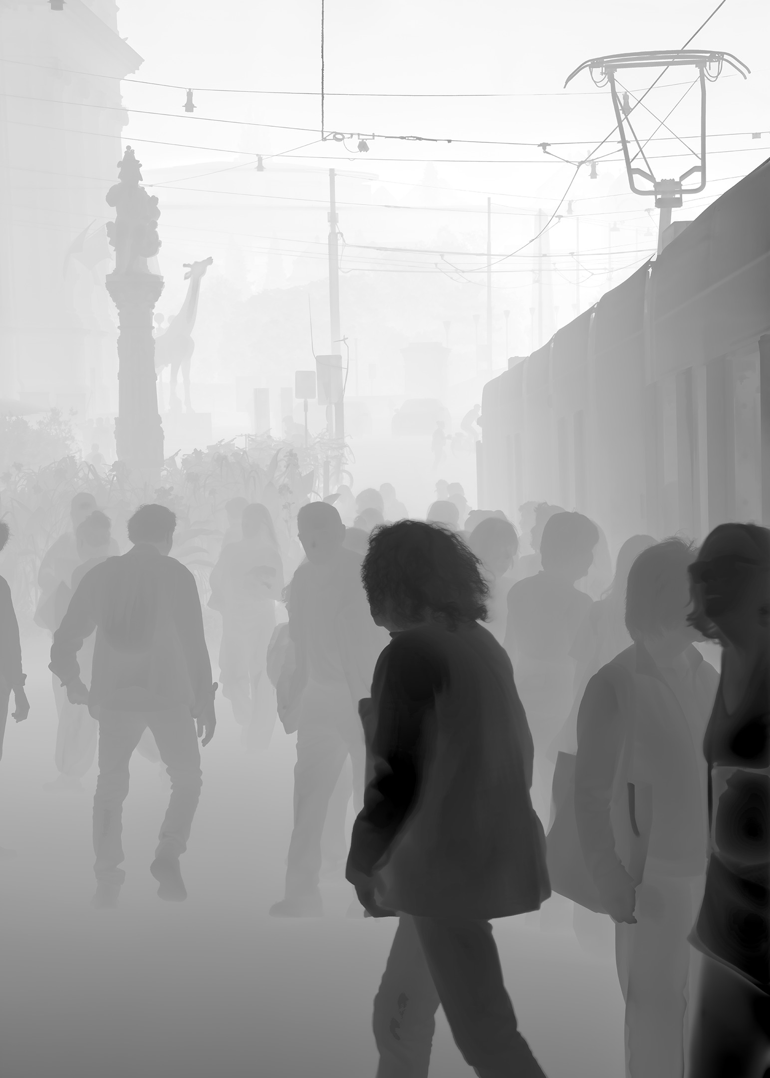 La foule du quai de tram en dégradé doux, les silhouettes proches sombres et le lointain pâle comme une brume.