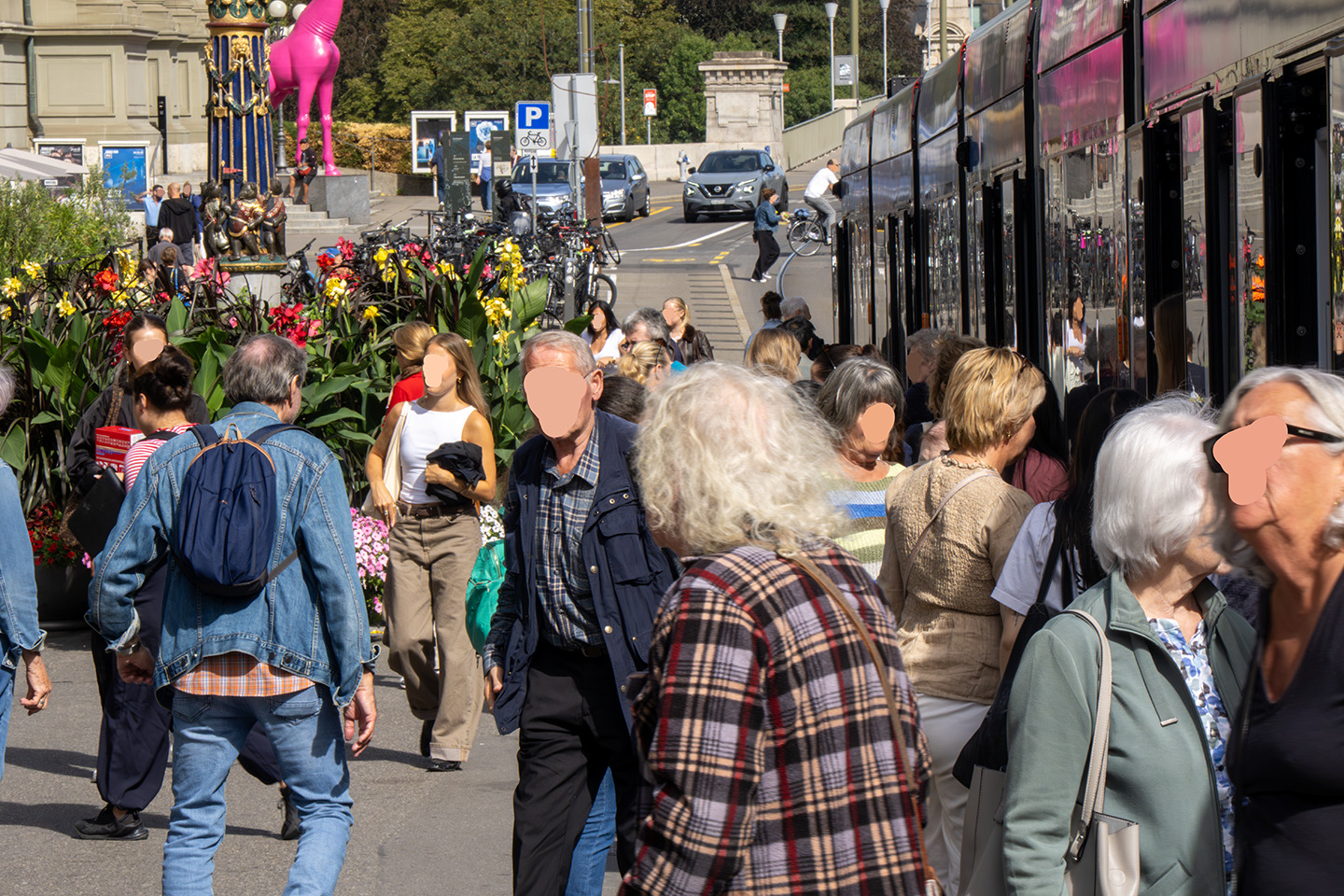 Une photographie d’une foule traversant un quai de tram à Berne.