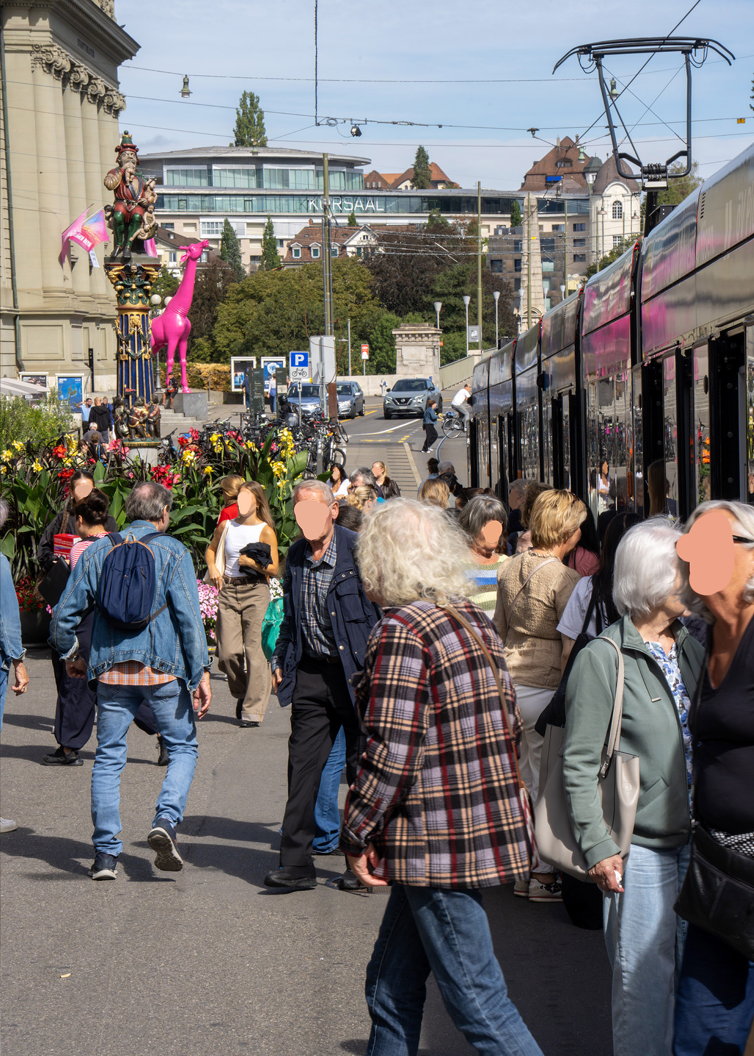 Une photographie d’une foule traversant un quai de tram à Berne.